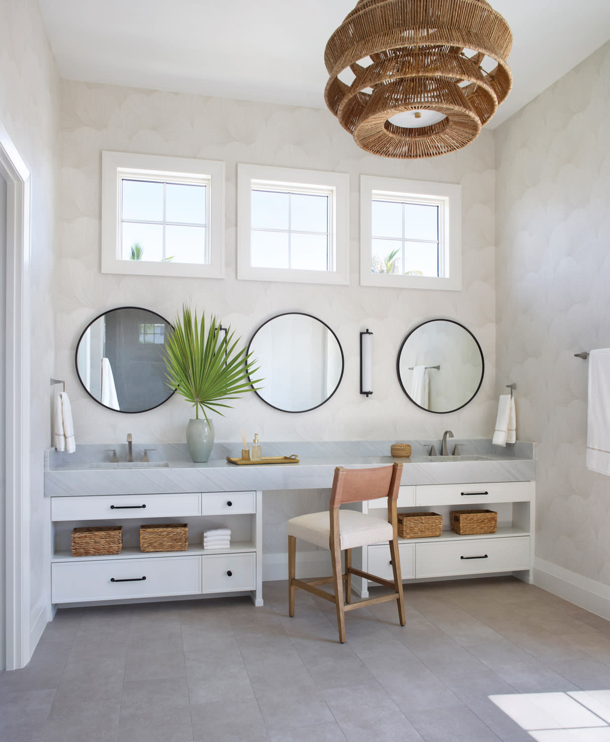 coastal bathroom with a row of circular mirrors above a double vanity