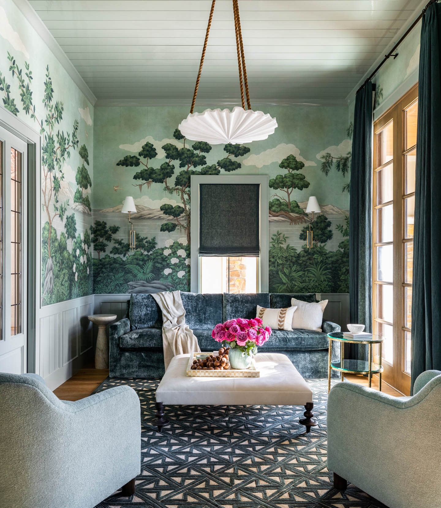 living room with scenic wallpaper, a blue sofa and light green armchairs