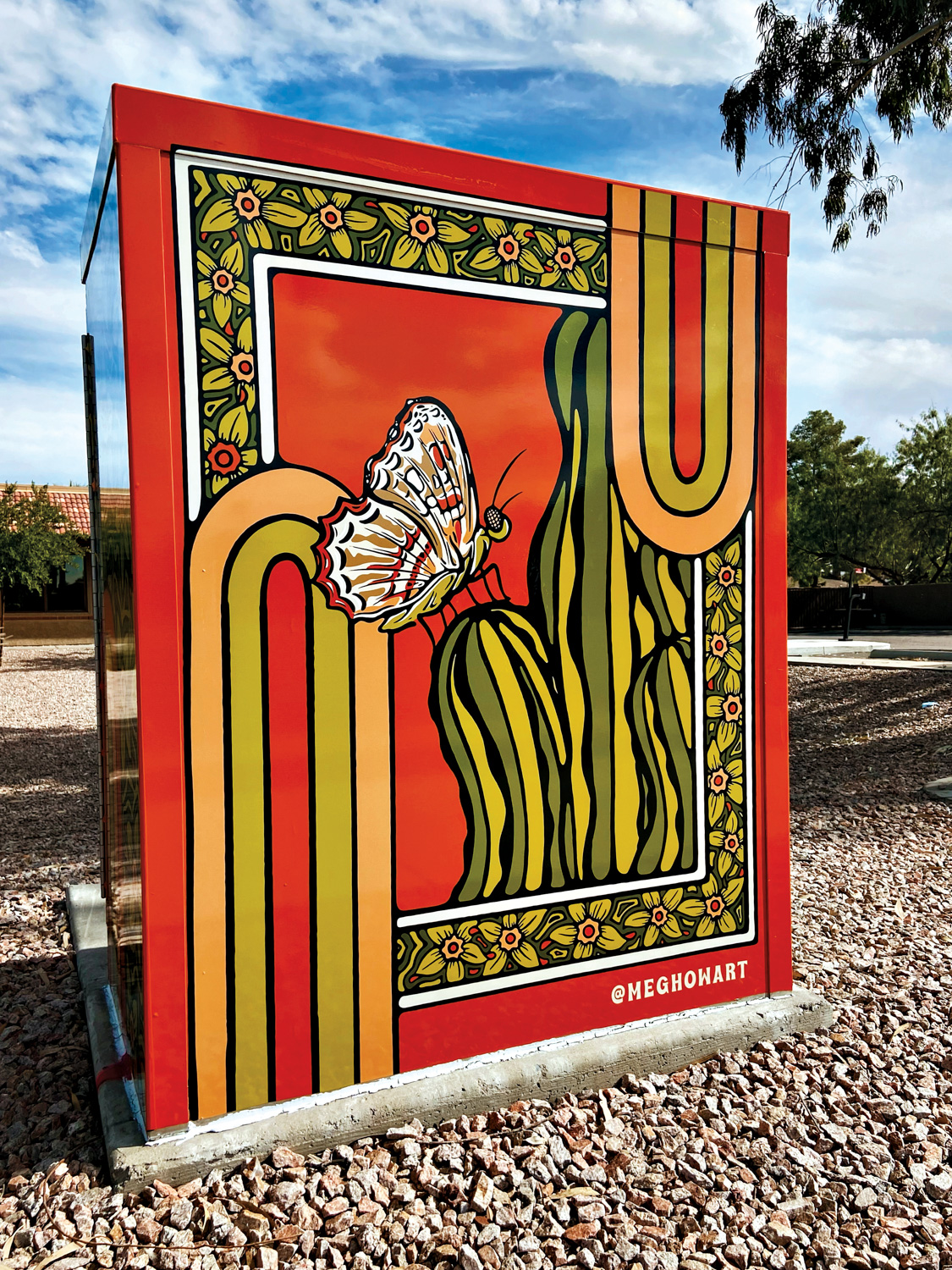 Painting of a butterfly on a cactus against a red backdrop on a utility box