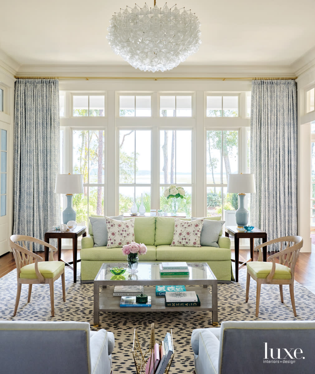 white living room with river views blue draperies and green chairs