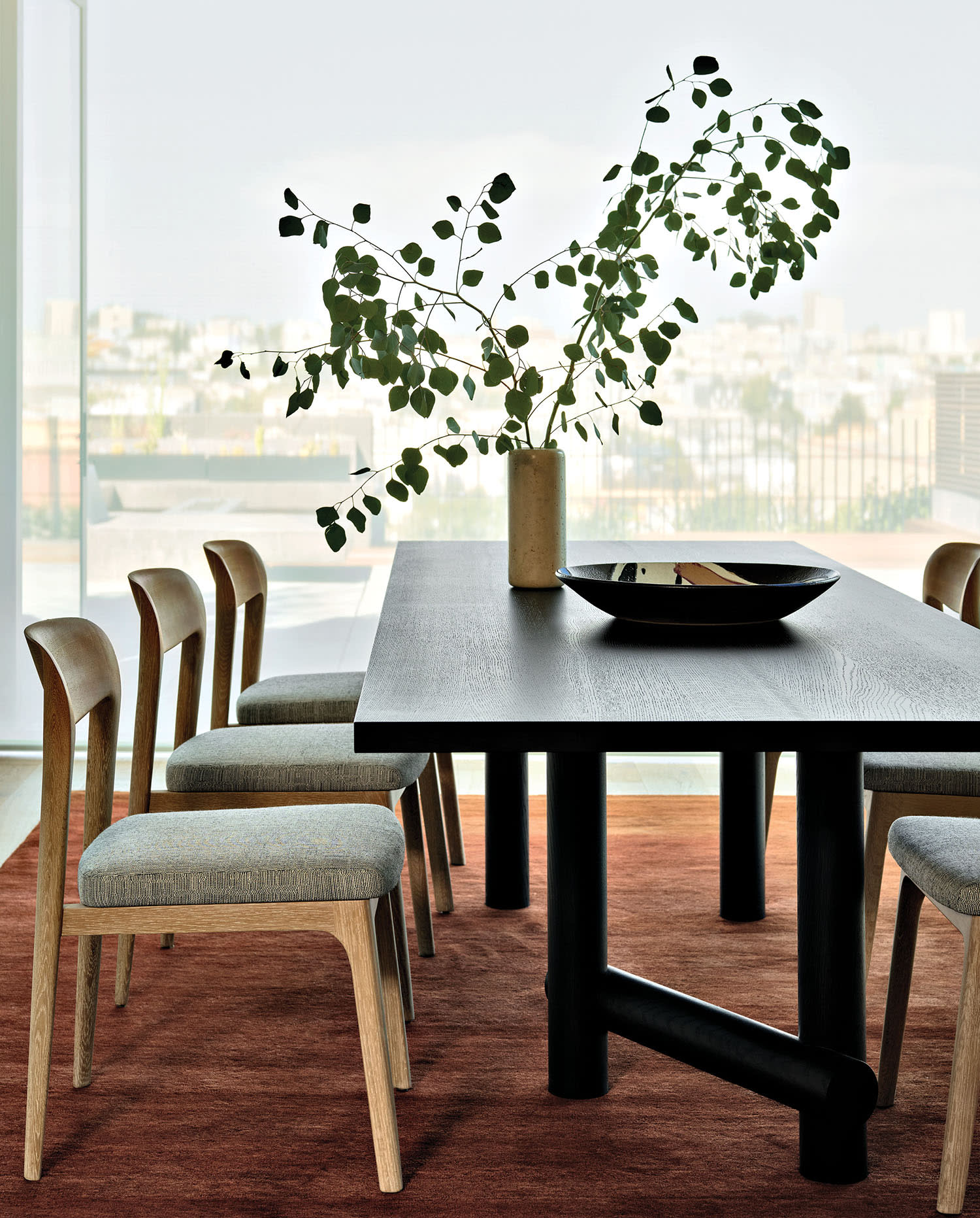contemporary oak dining table atop a red rug