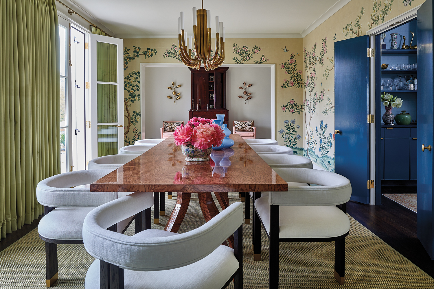 Large dining room with chinoiserie wallpaper and burl wood dining table