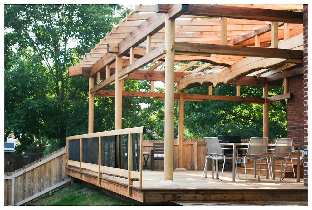 Wooden outdoor deck with wood and timber beams and wood railing.