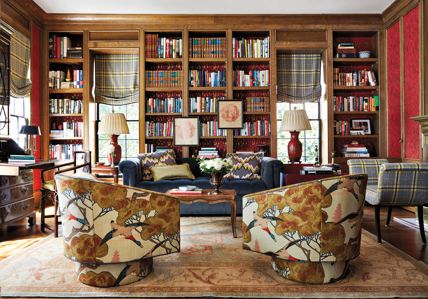 traditional home library with wood shelving, plaid seating 