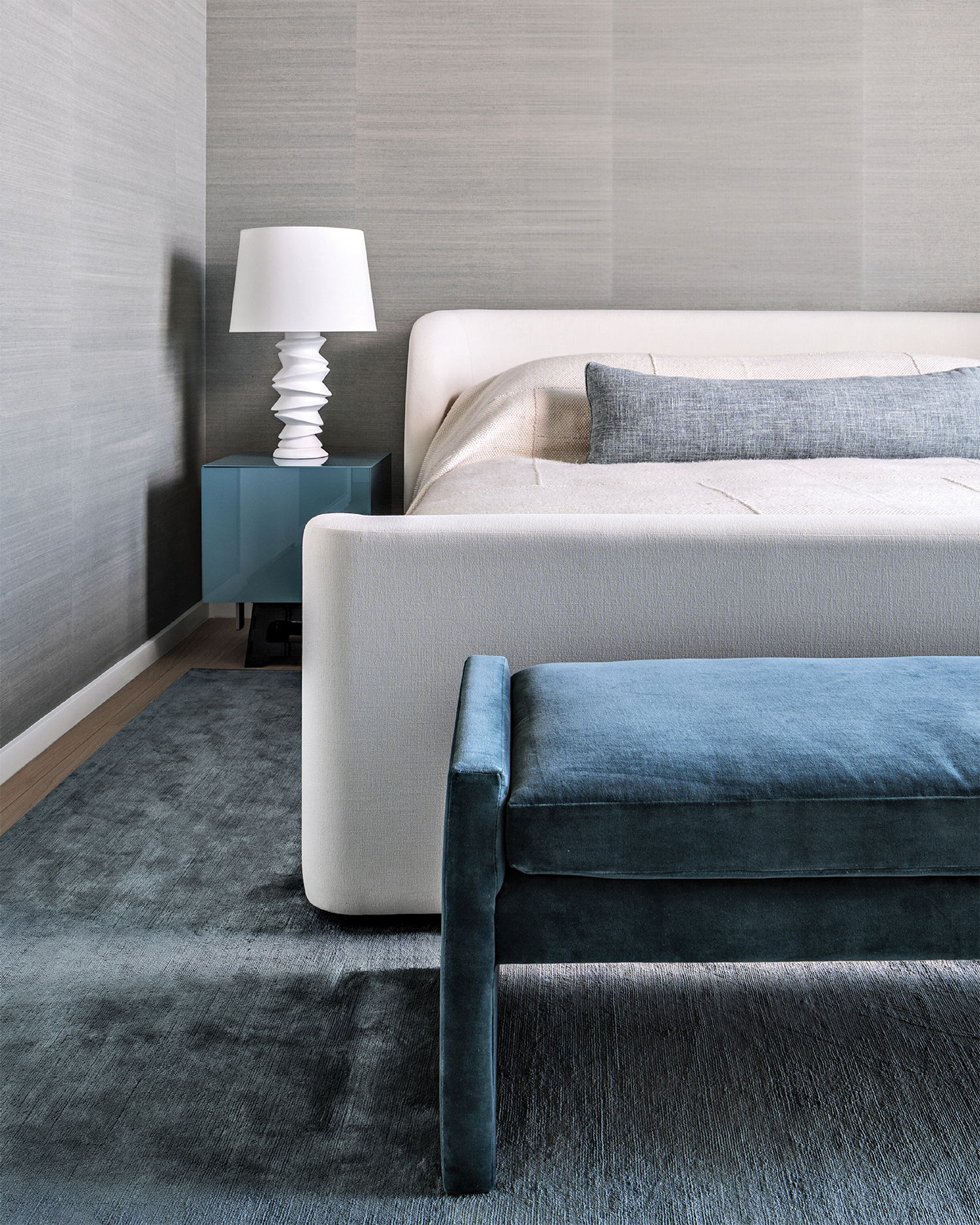 grey guest bedroom with a white bed and blue carpeting