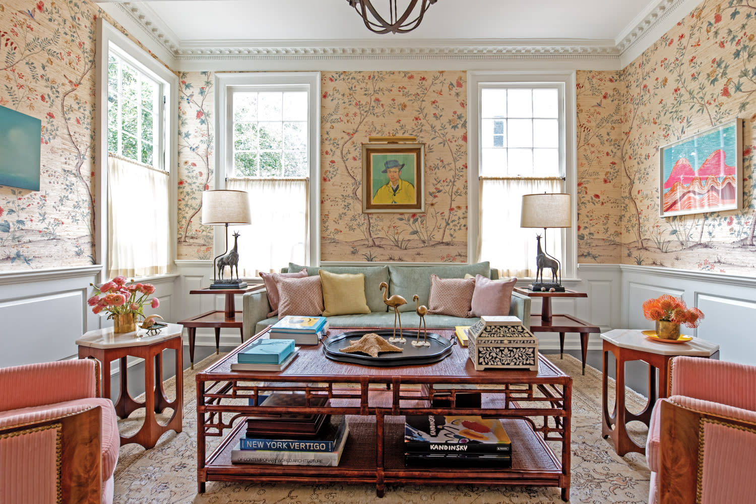 Sun room with floral walls, red bamboo furnishings and colorful artworks