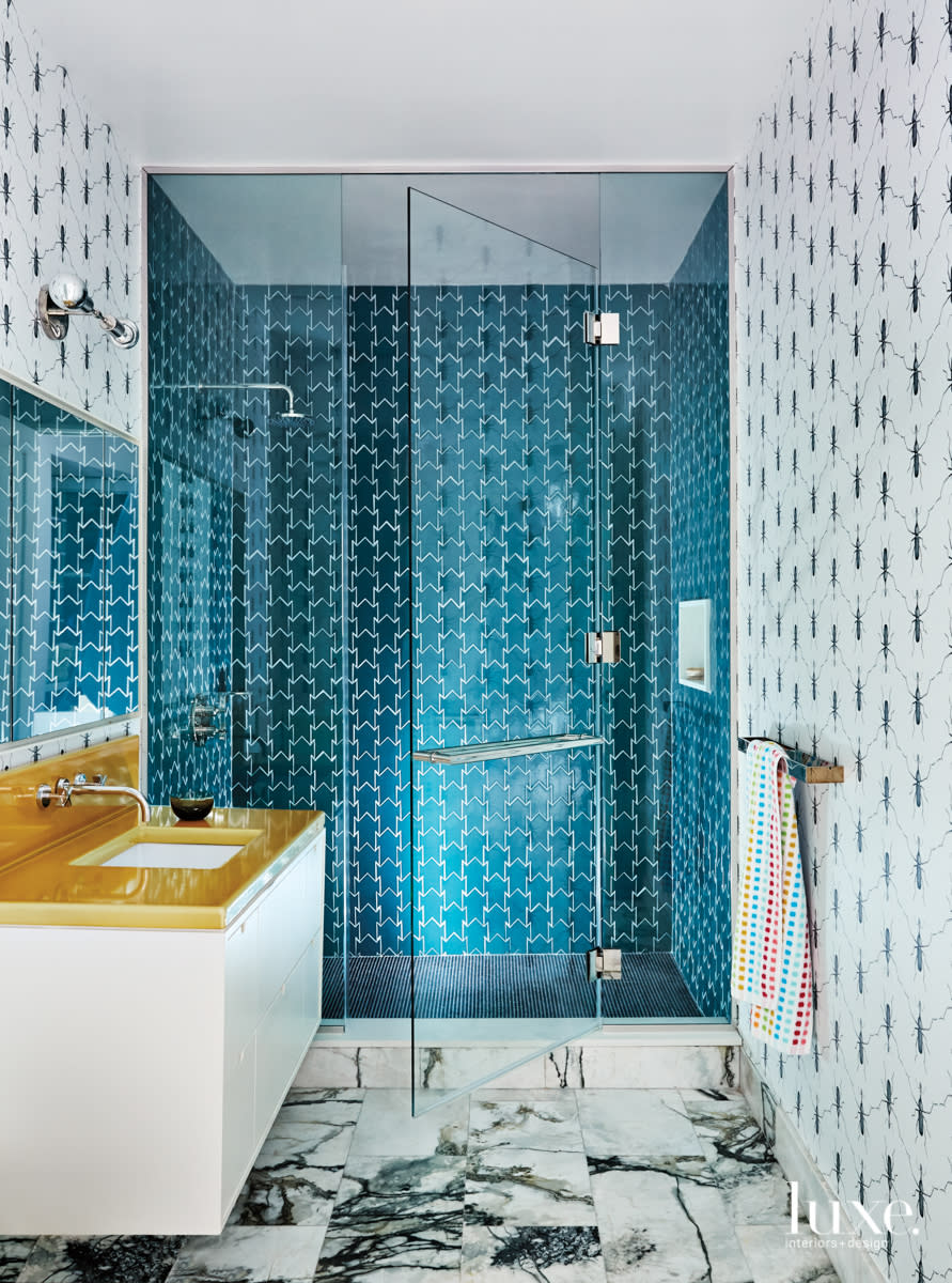 bathroom with blue tile shower and bugs on wallpaper