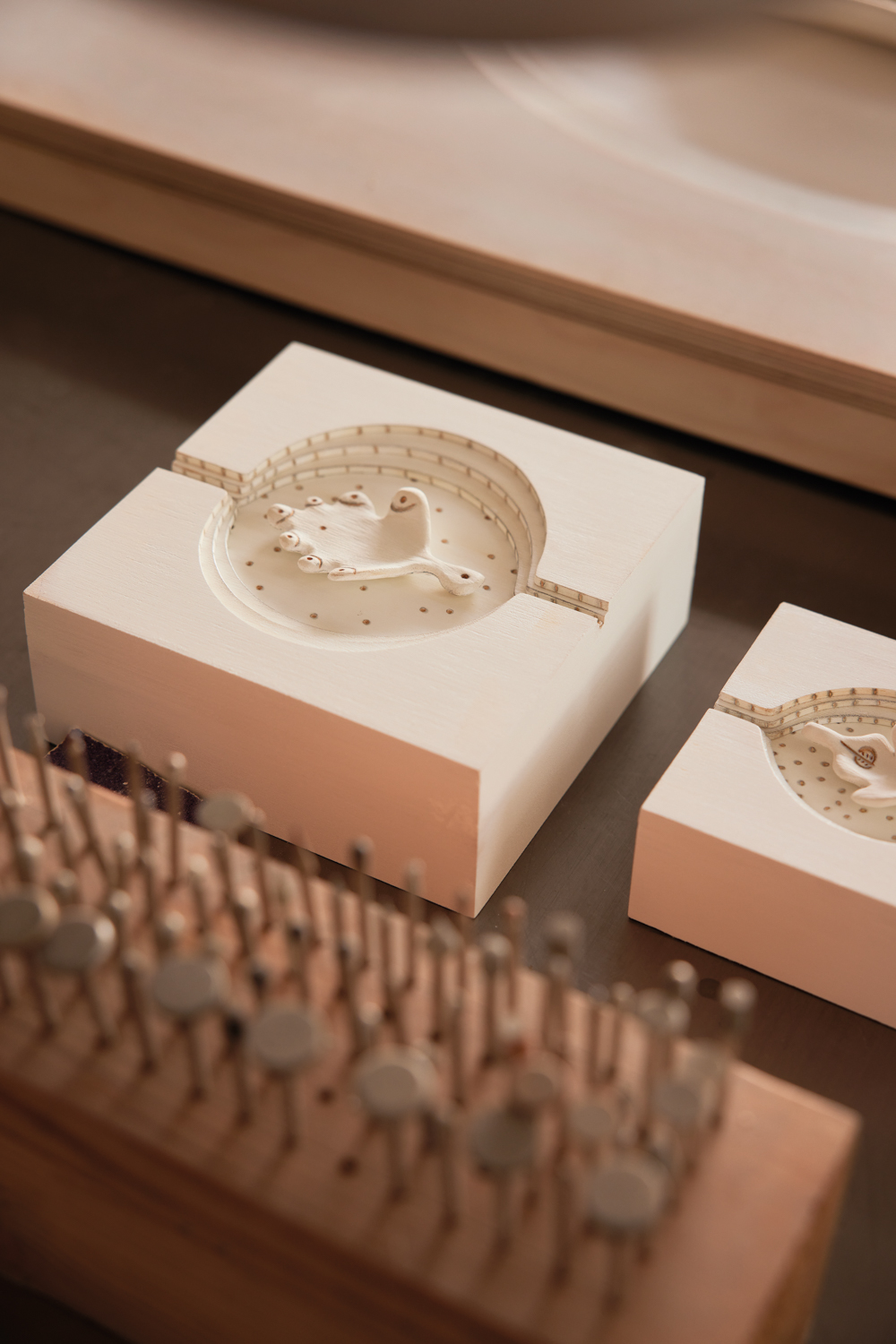 Two square carved porcelain pieces with carvings of leaves in the center.