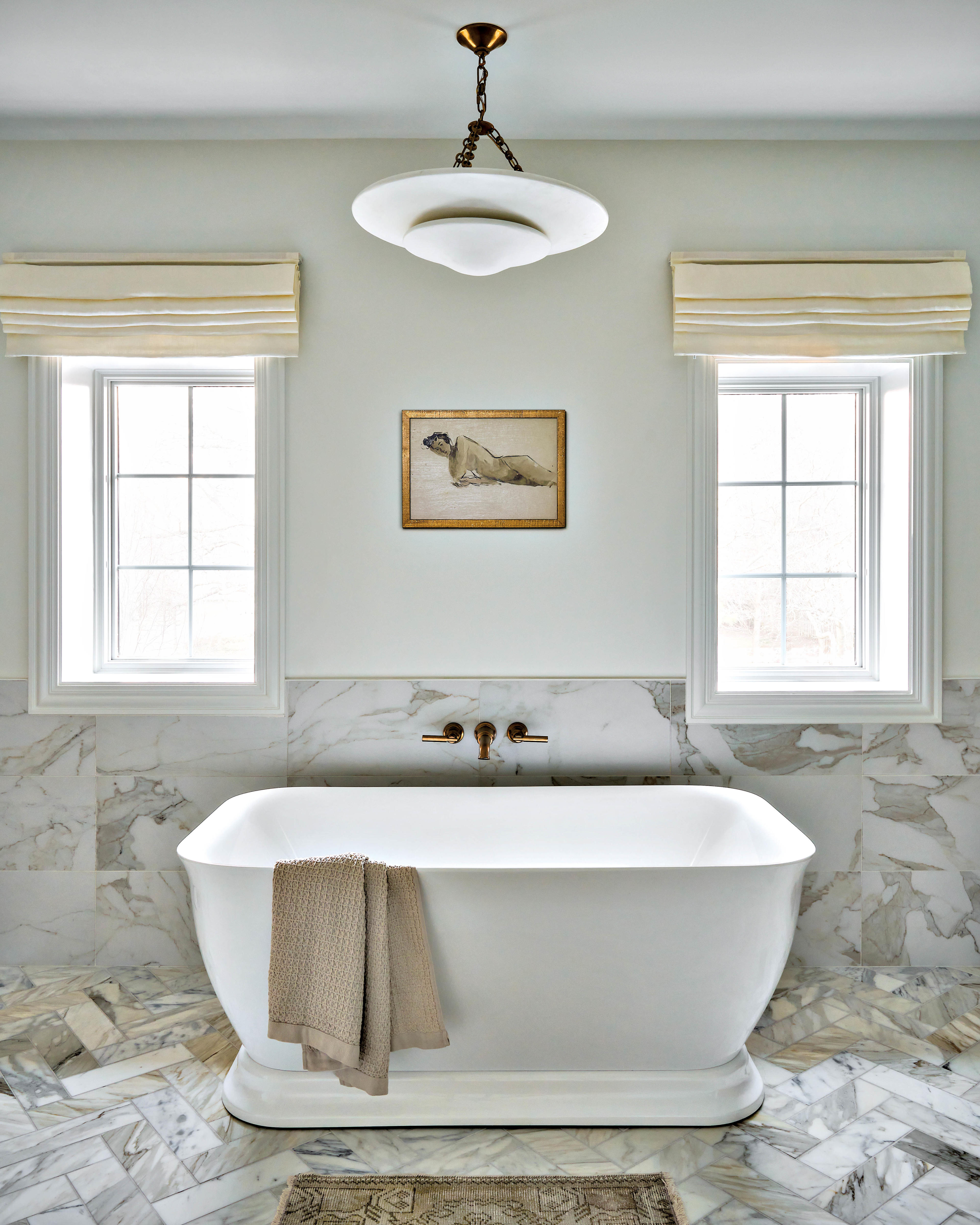 a white and grey marble floor in a herringbone pattern lines this modern bathroom