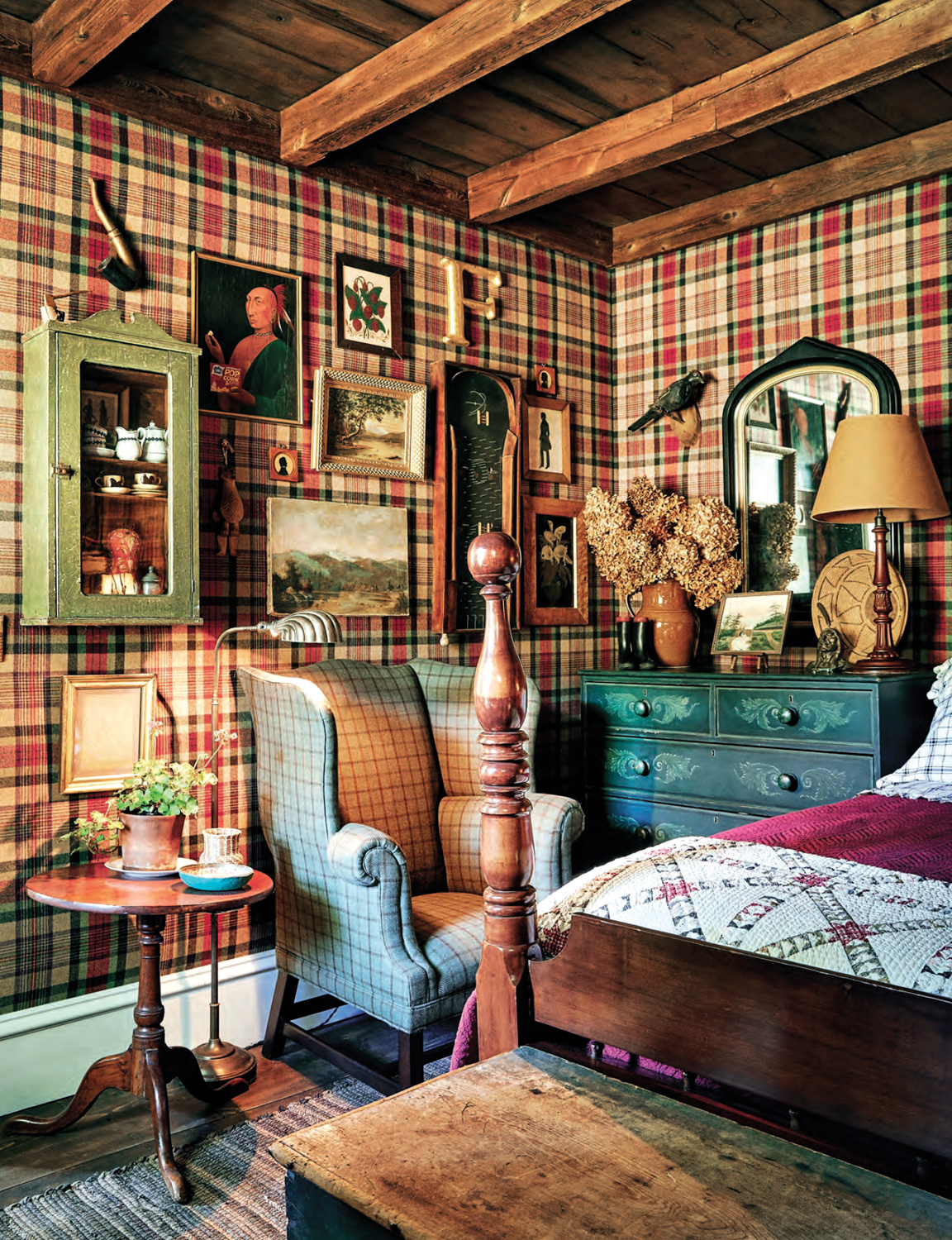 Bedroom with tartan walls, a four-poster bed, antique artworks and dark-wood ceiling beams by William Abranowicz