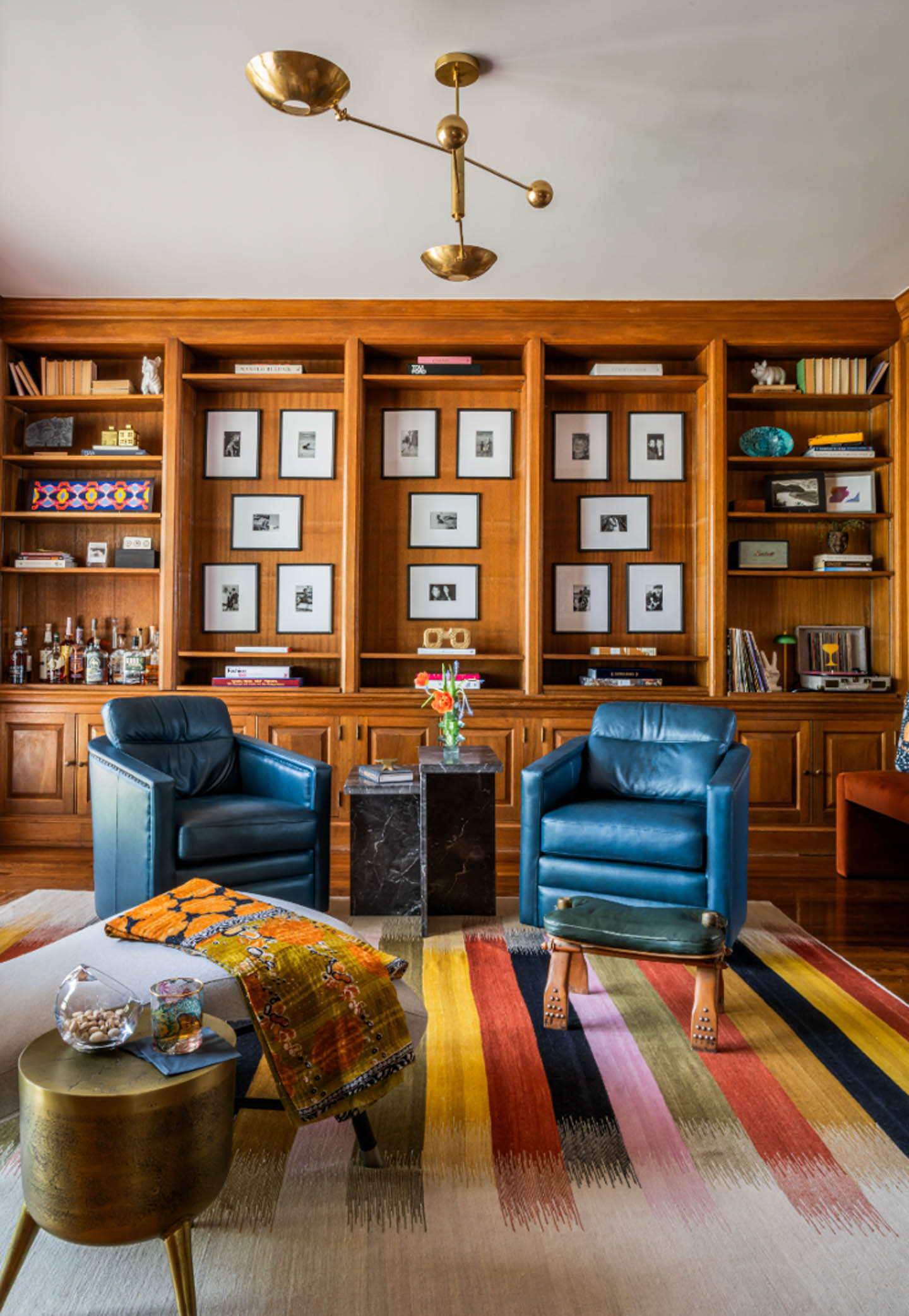 a colorful striped rug in a lounge with blue armchairs