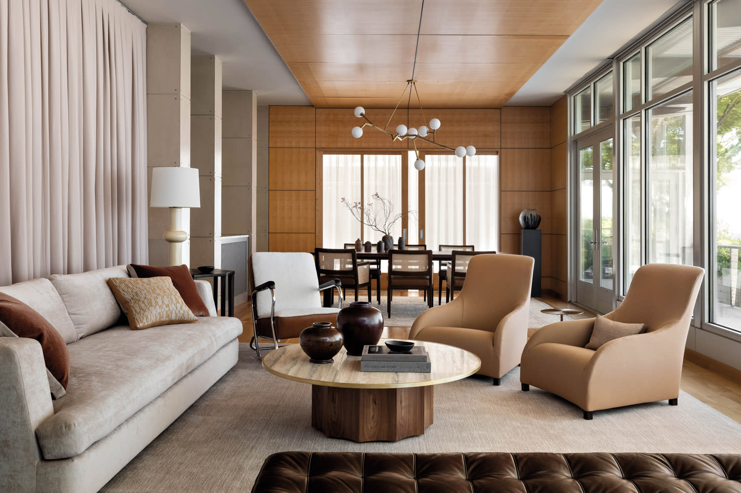 A tan sofa and chairs are positioned around a circular coffee table