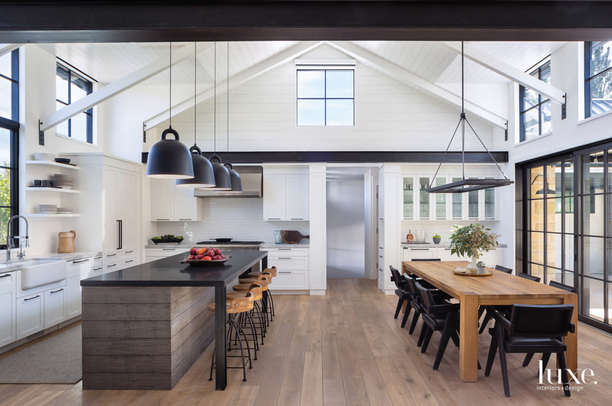 kitchen with two sets of dining areas, one table with chairs and one island sith barstools