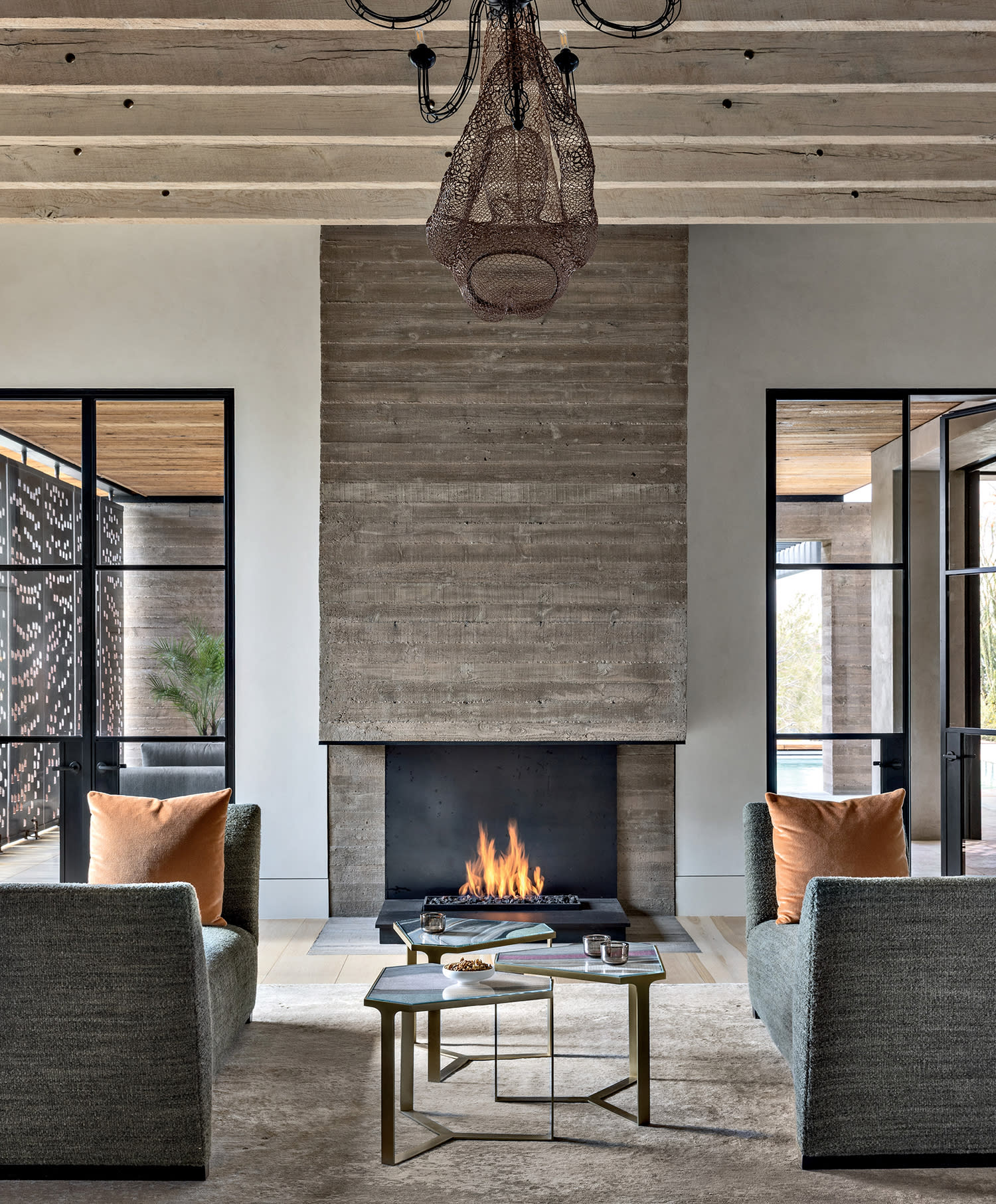 living room with exposed beams and a tall fireplace