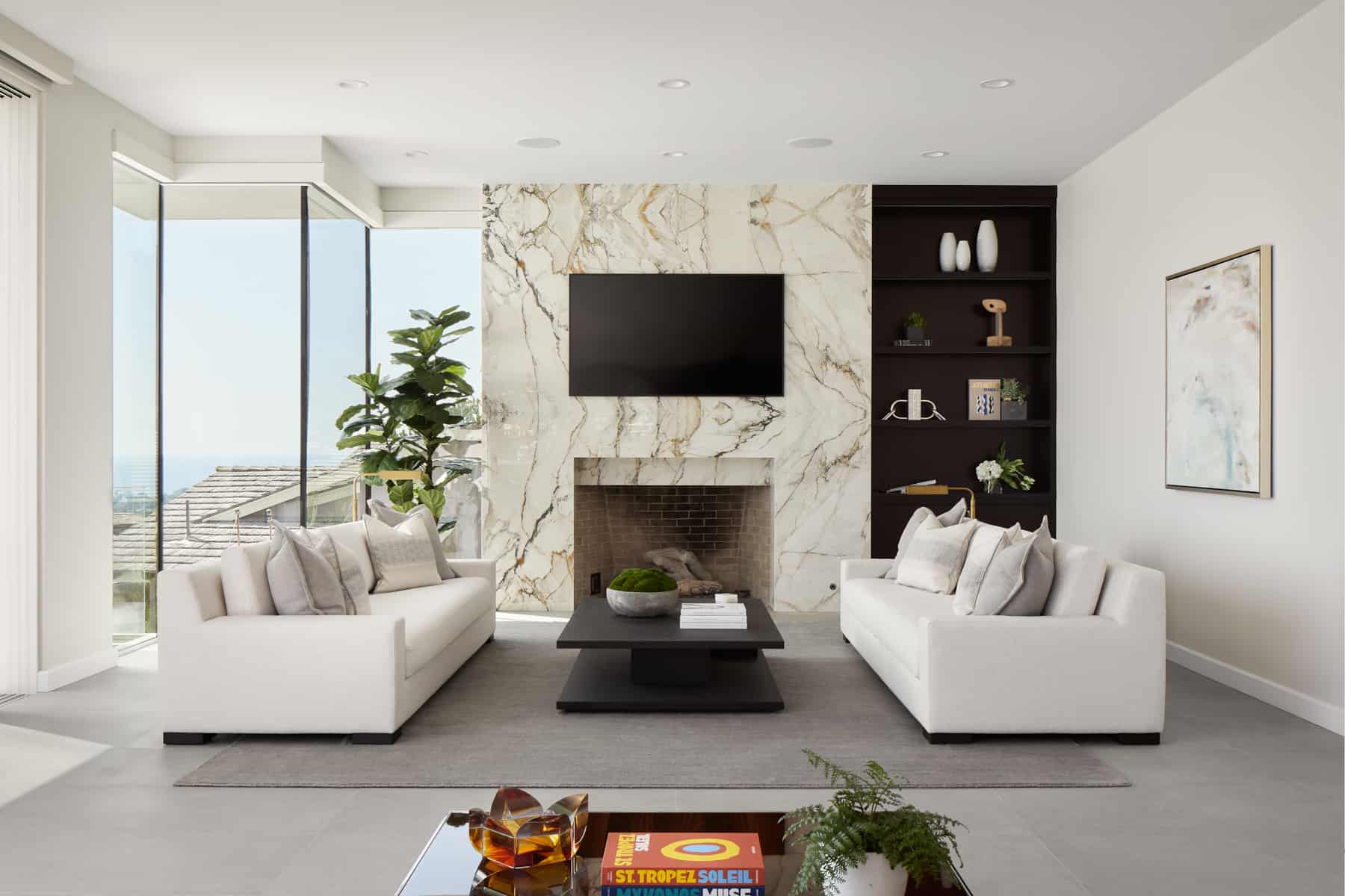 A modern living room designed by Payton Addison featuring white furniture and a warm fireplace, creating a bright and inviting atmosphere. 