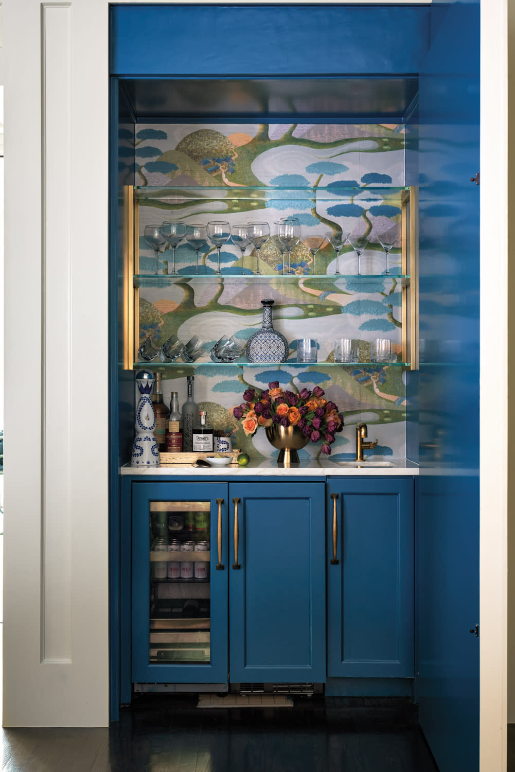 hidden bar featuring wallpaper and bold blue cabinetry