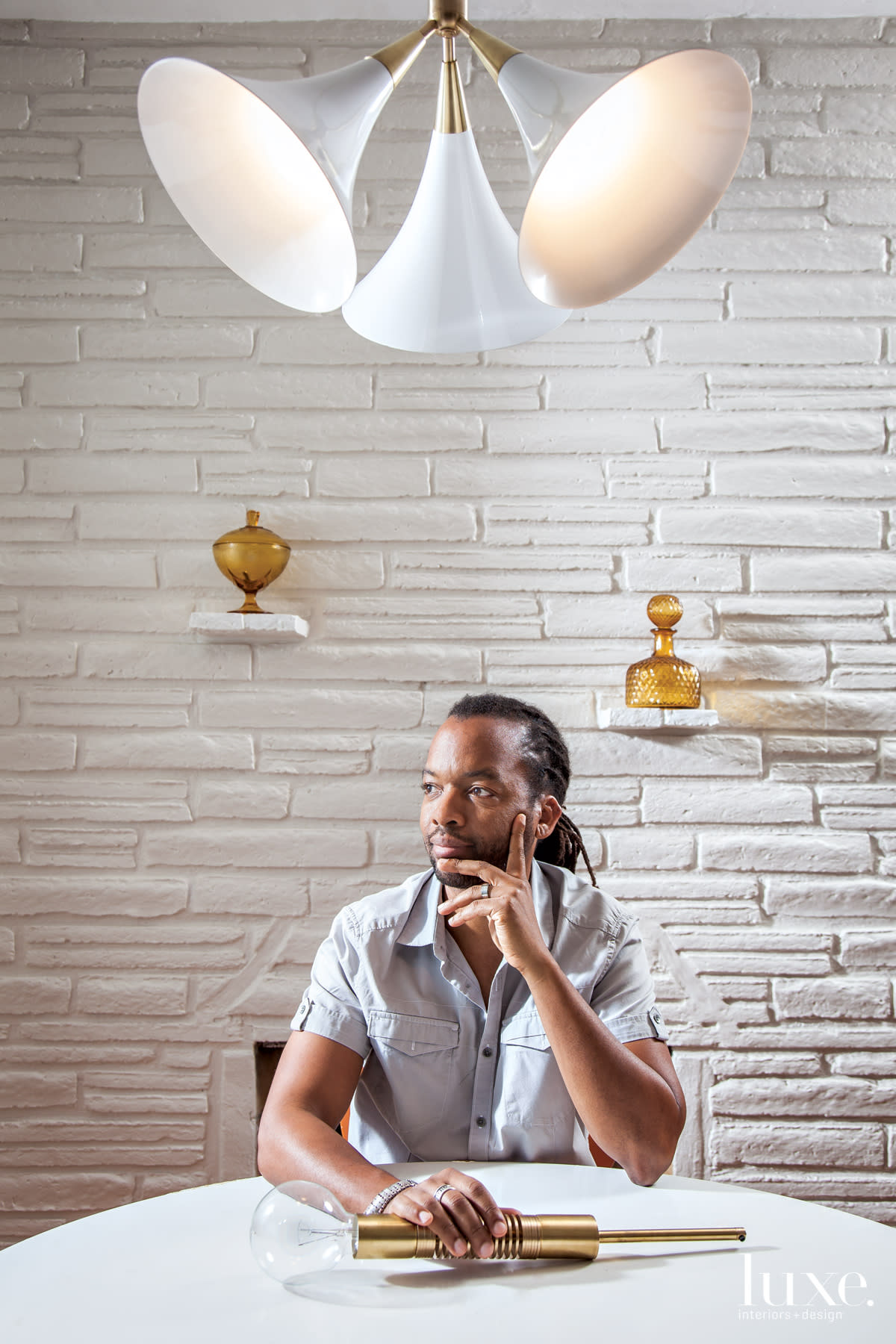 Lighting designer Raymond Barberousse sits among some of his creations.