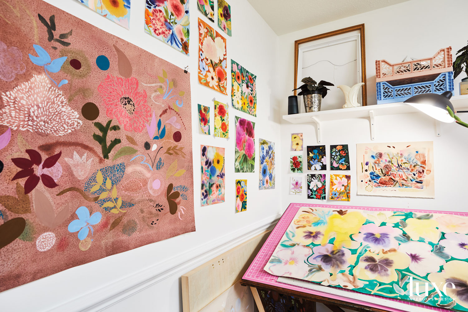 Corner of an artist studio with a pink drafting table and shelf