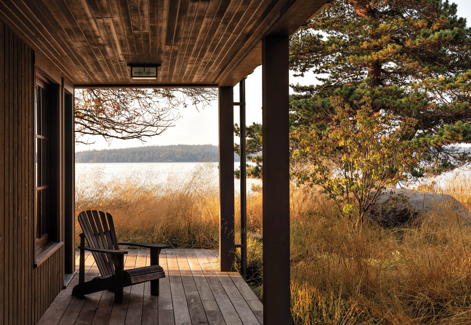 An Adirondack chair sits on a deck with a view.