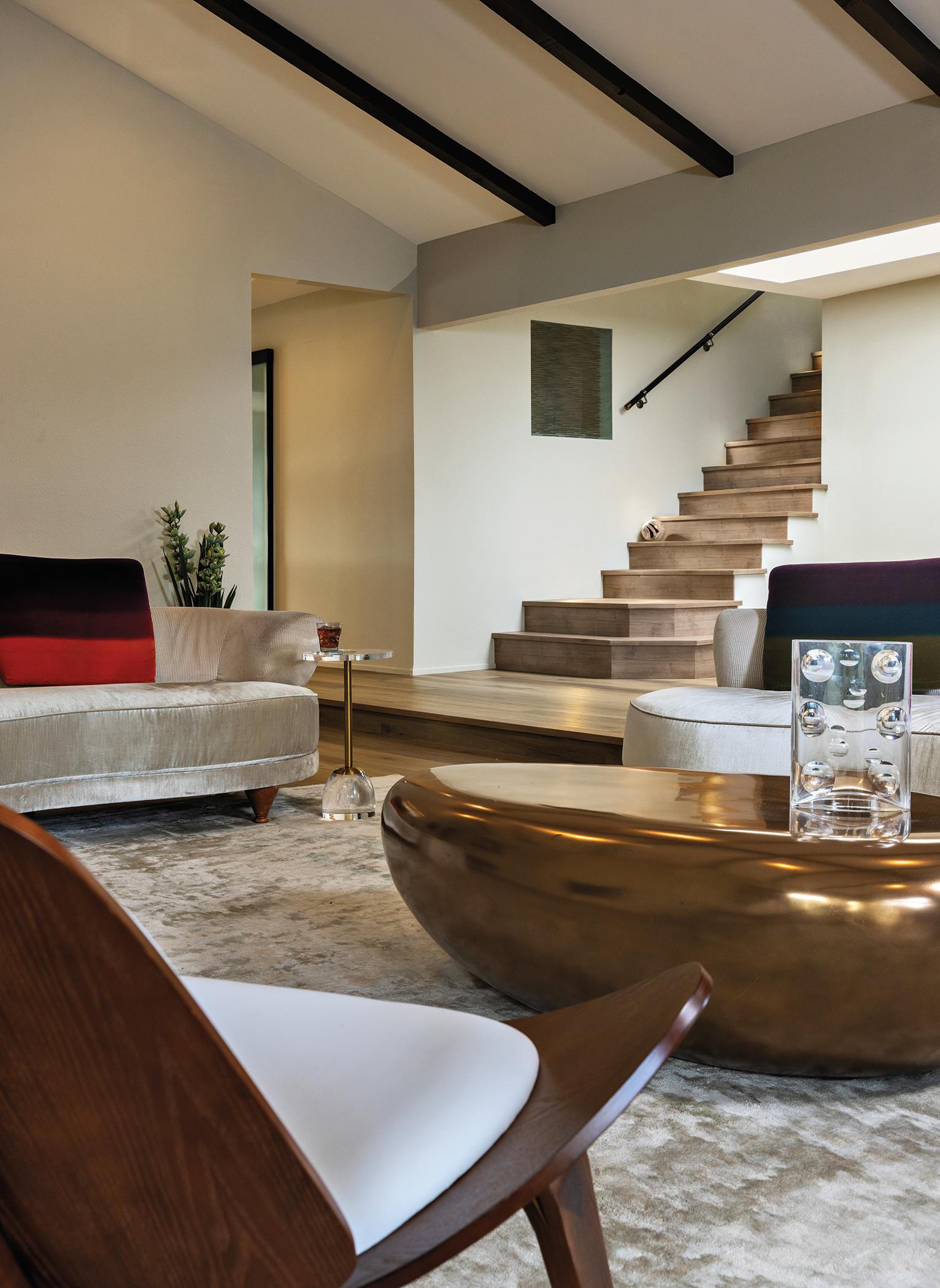 Open-concept view of the Pazzam Project kitchen and living area, demonstrating cohesive materiality, concealed storage, and architectural continuity.