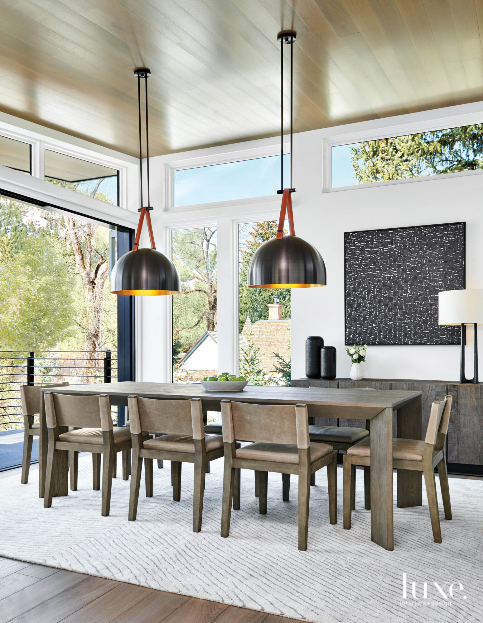 A dining room has two dome light fixtures over a long table.