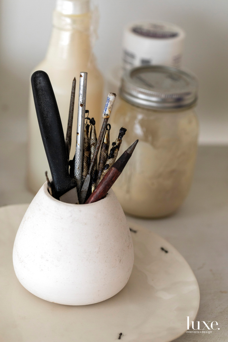 a ceramic pencil cup containing tools