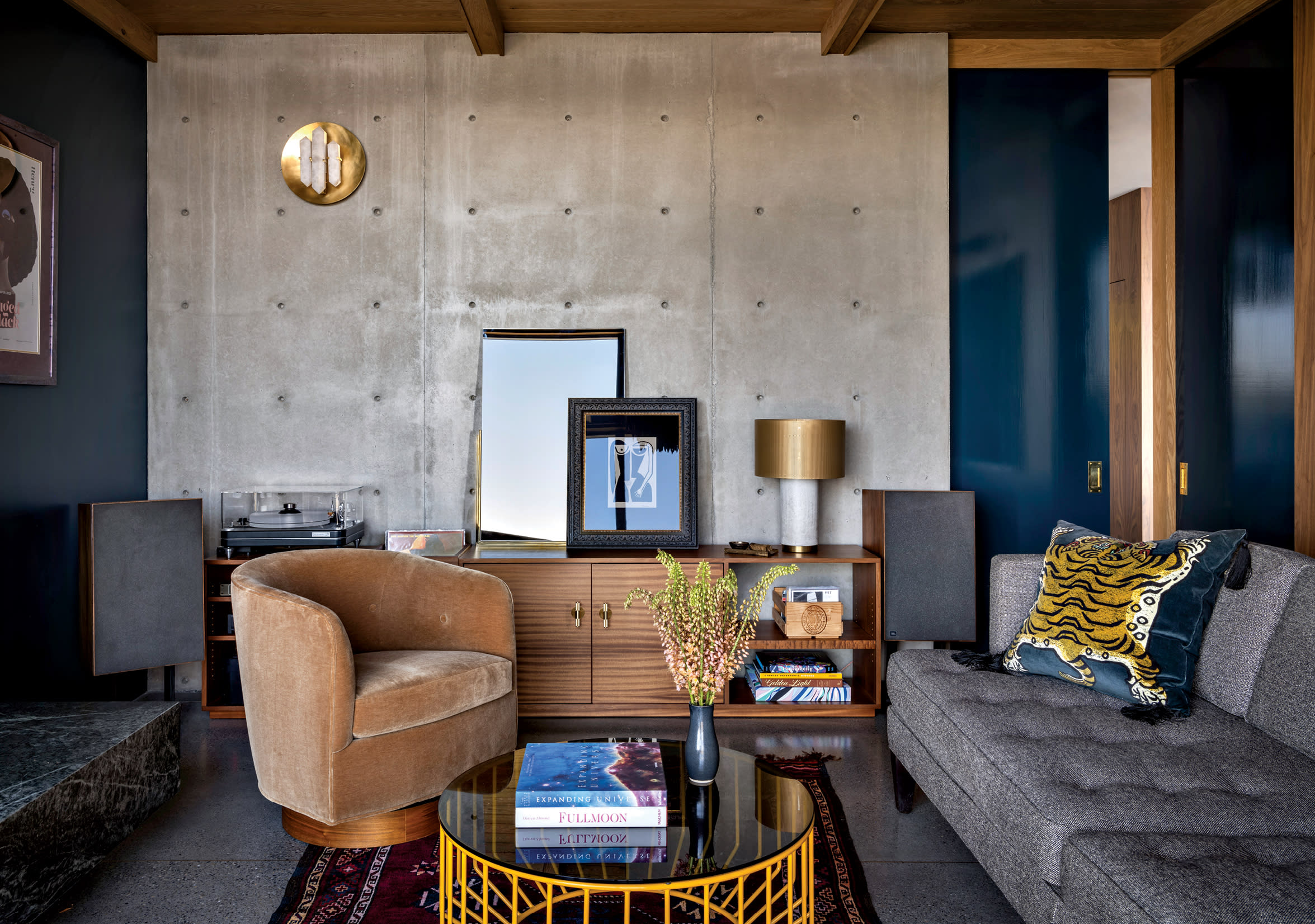 vintage meets modern living room with an exposed concrete wall giving it a Brutalist aesthetic