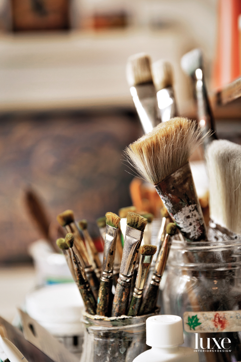 Paint brushes rest in jars.