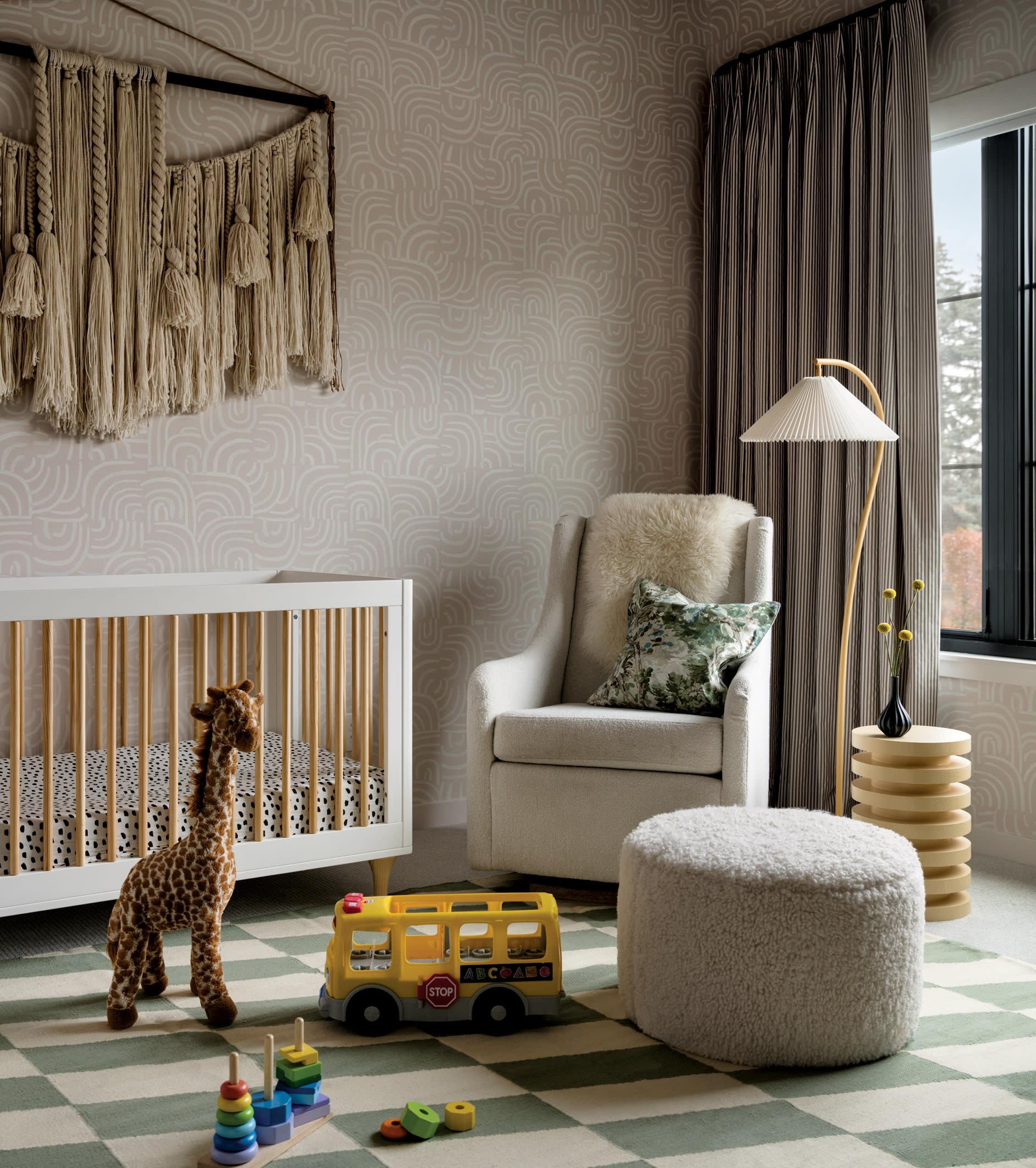 contemporary nursery with a textile wallhanging and a giraffe stuffed animal