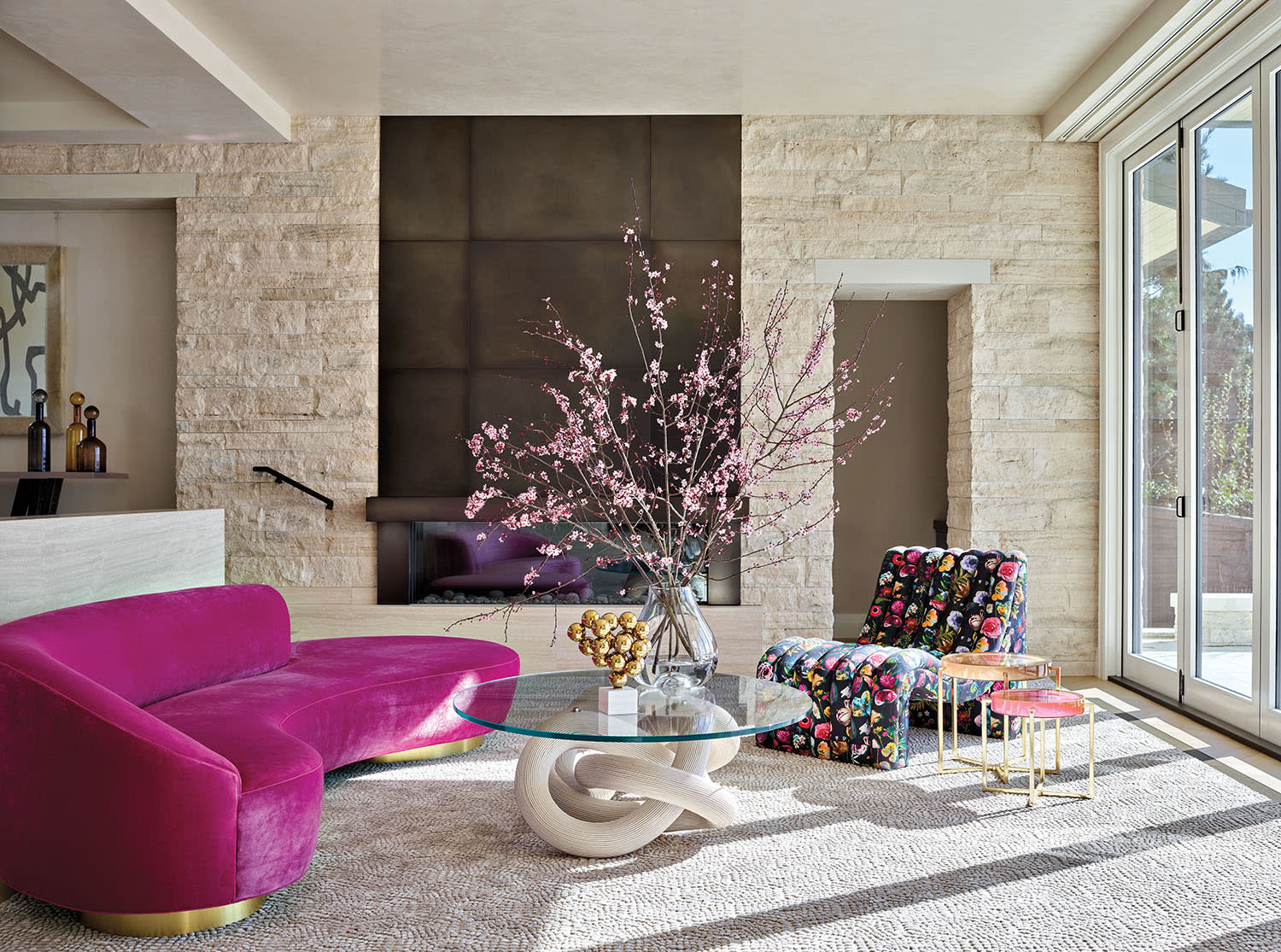 modern living space with pink couch and floral chaise