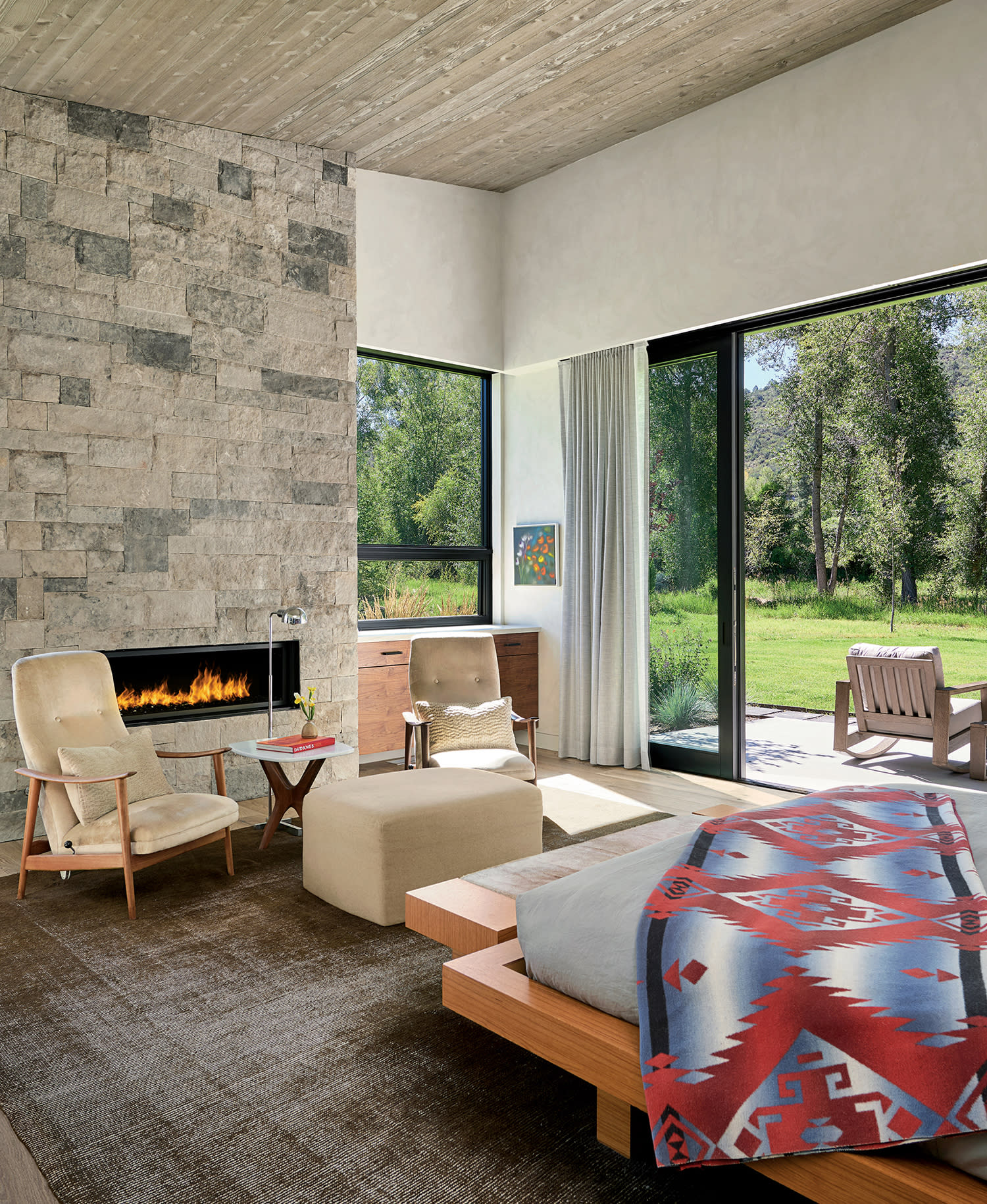 modern bedroom with a limestone-lined fireplace 