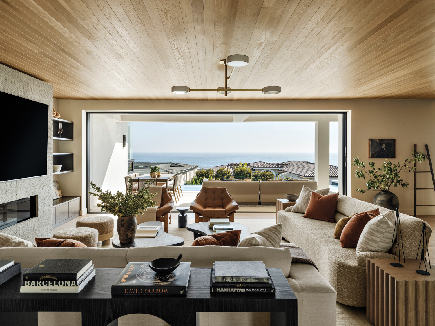 indoor-outdoor living area with assorted seating and a divided coffee table opens to an outdoor pool