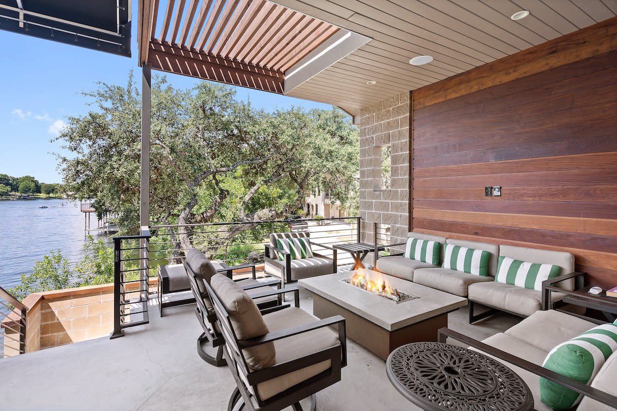 A scenic patio with comfortable couches and a fire pit, offering a picturesque view of the water.