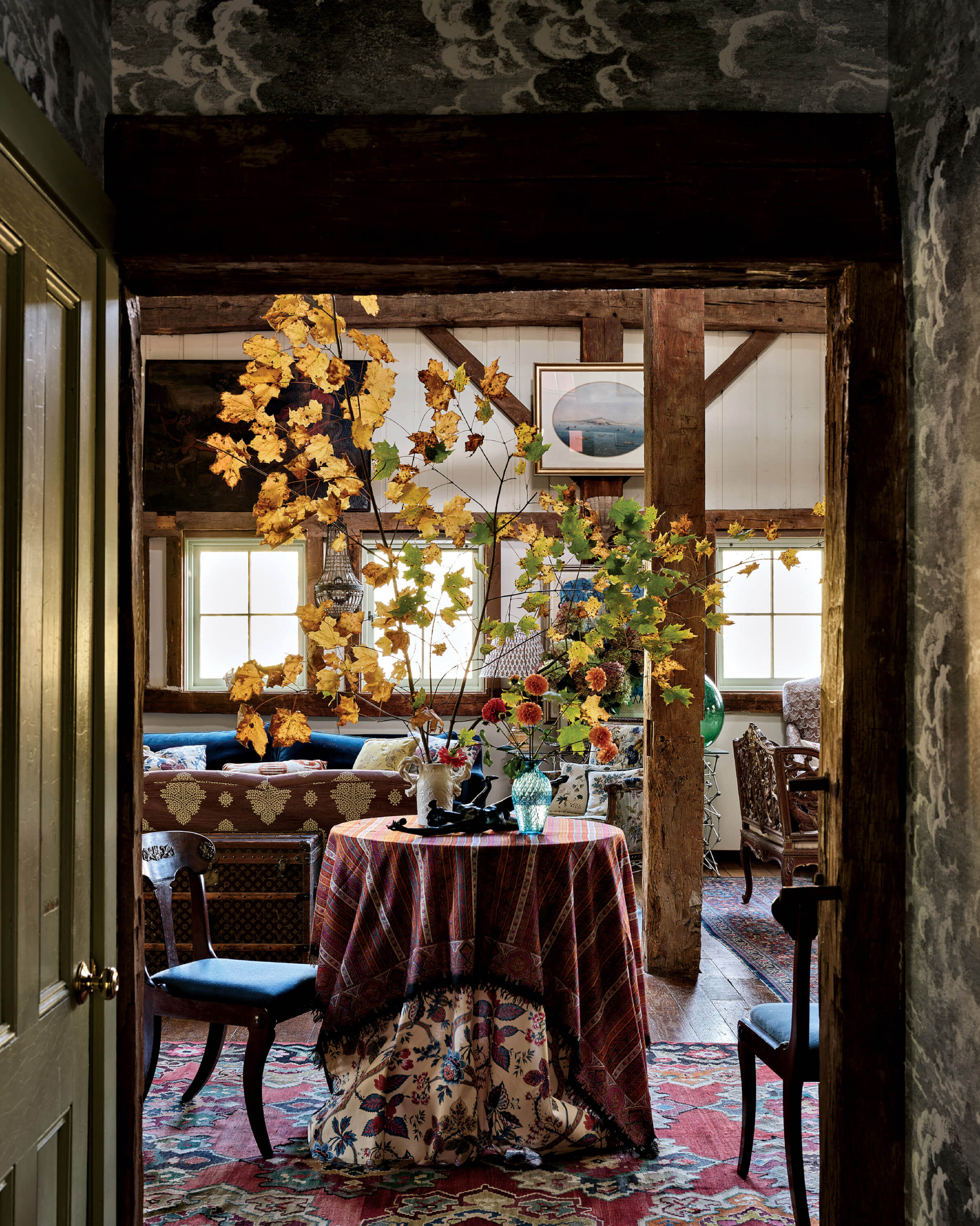 family room in moody colors with a table with a fall leaf centerpiece