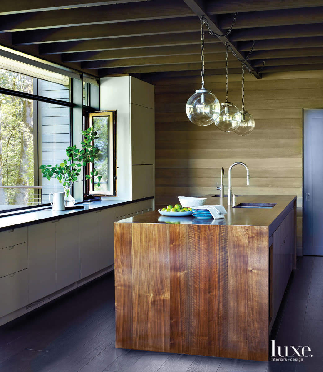 walnut island with a window view and three glass pendants