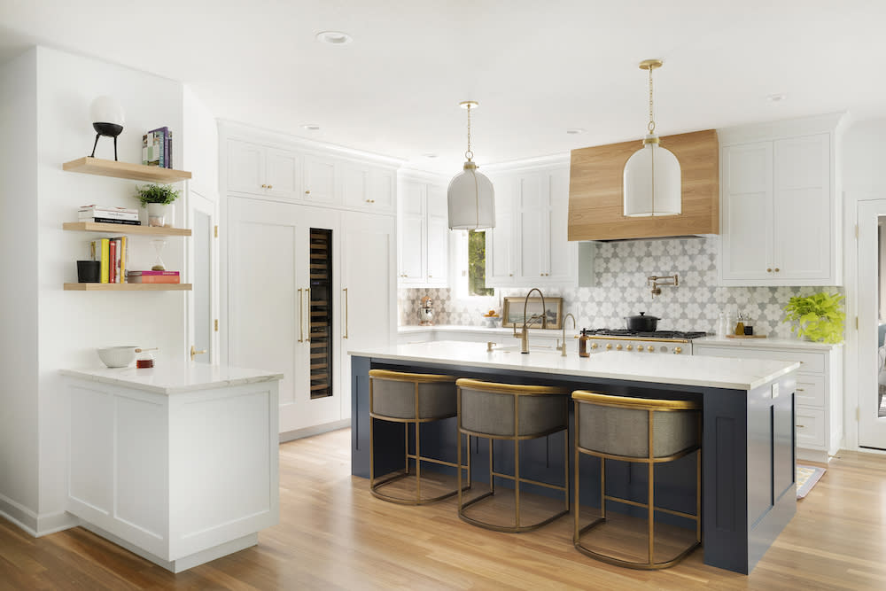 Wood range hood and navy island provide balance and warmth in this classic kitchen. 