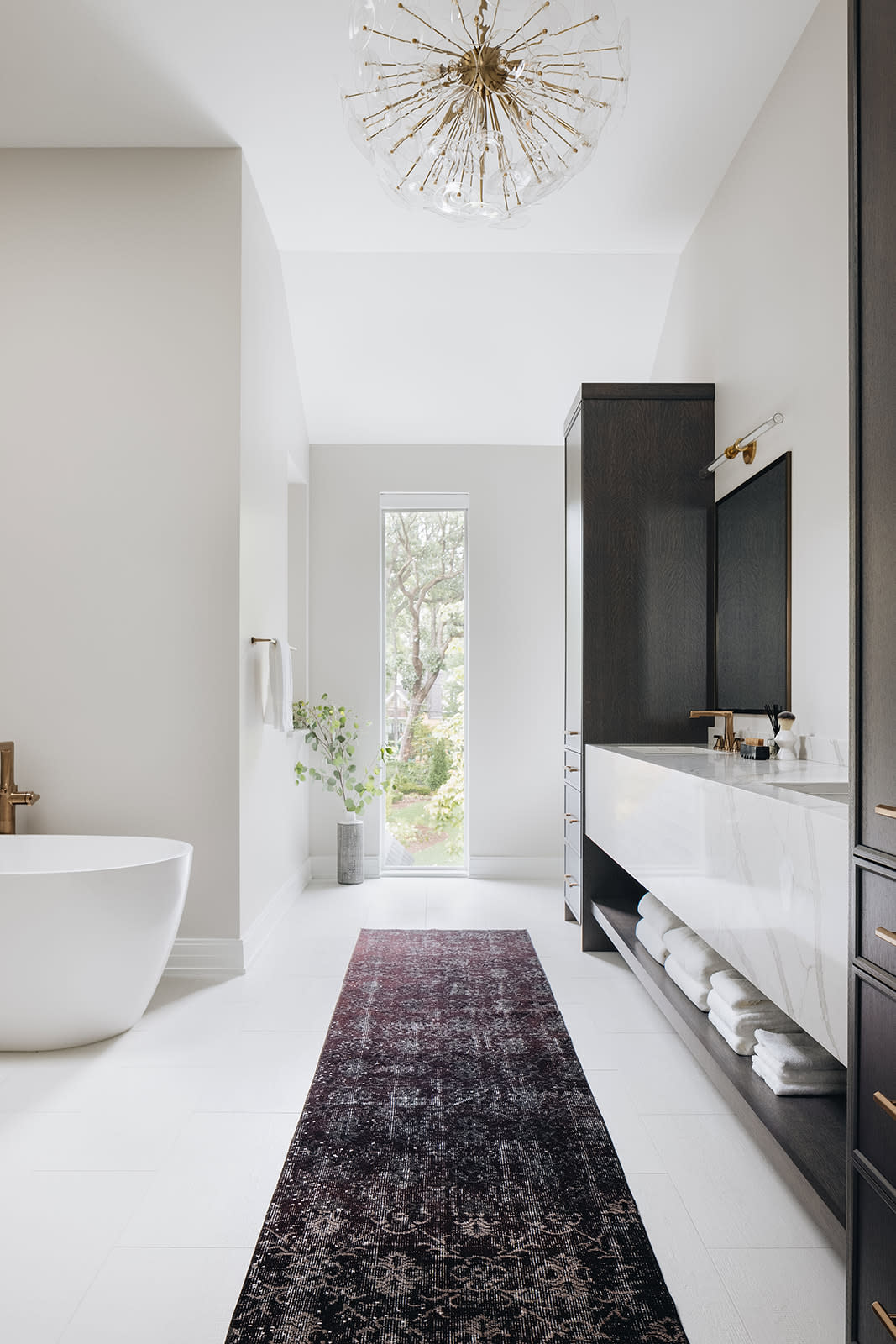 white primary bathroom with purple runner and cabinets for storage