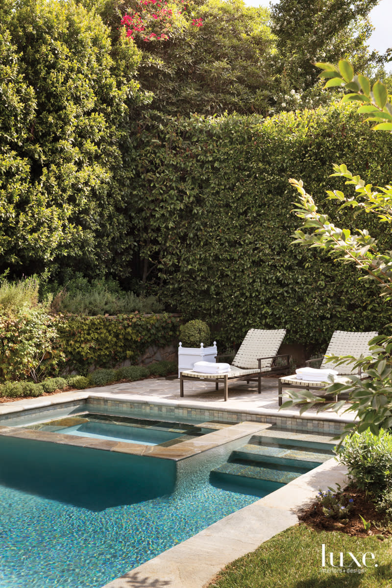 View to the pool with two chaise lounges.