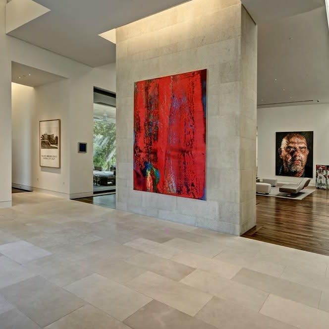 A grand painting adorns the center of a spacious room, capturing attention with its size and beauty.