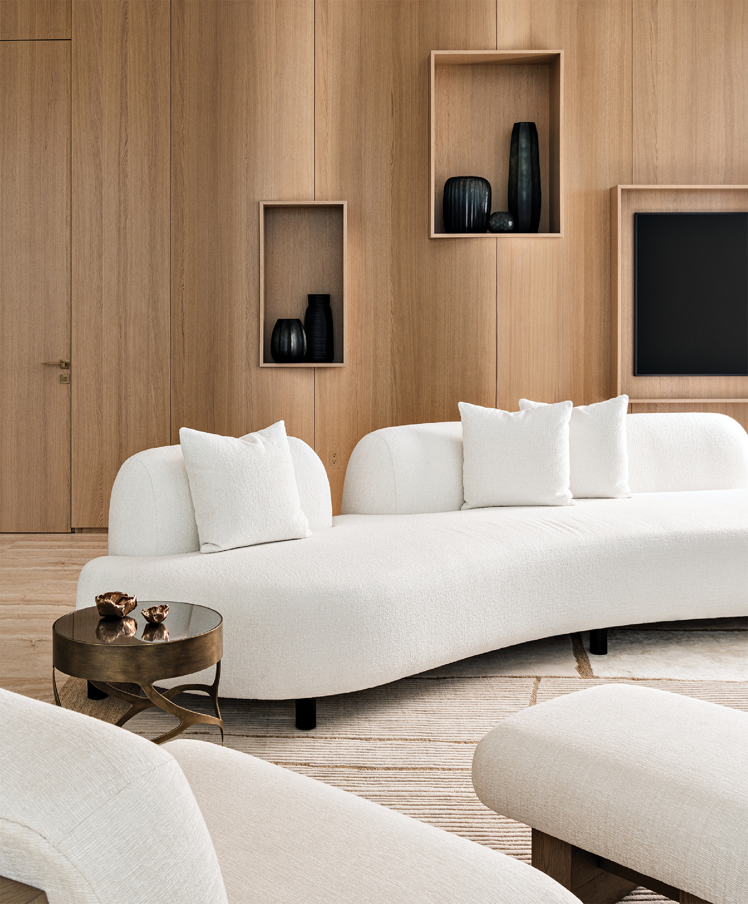 light oak walls surround a curving white sofa in this living room