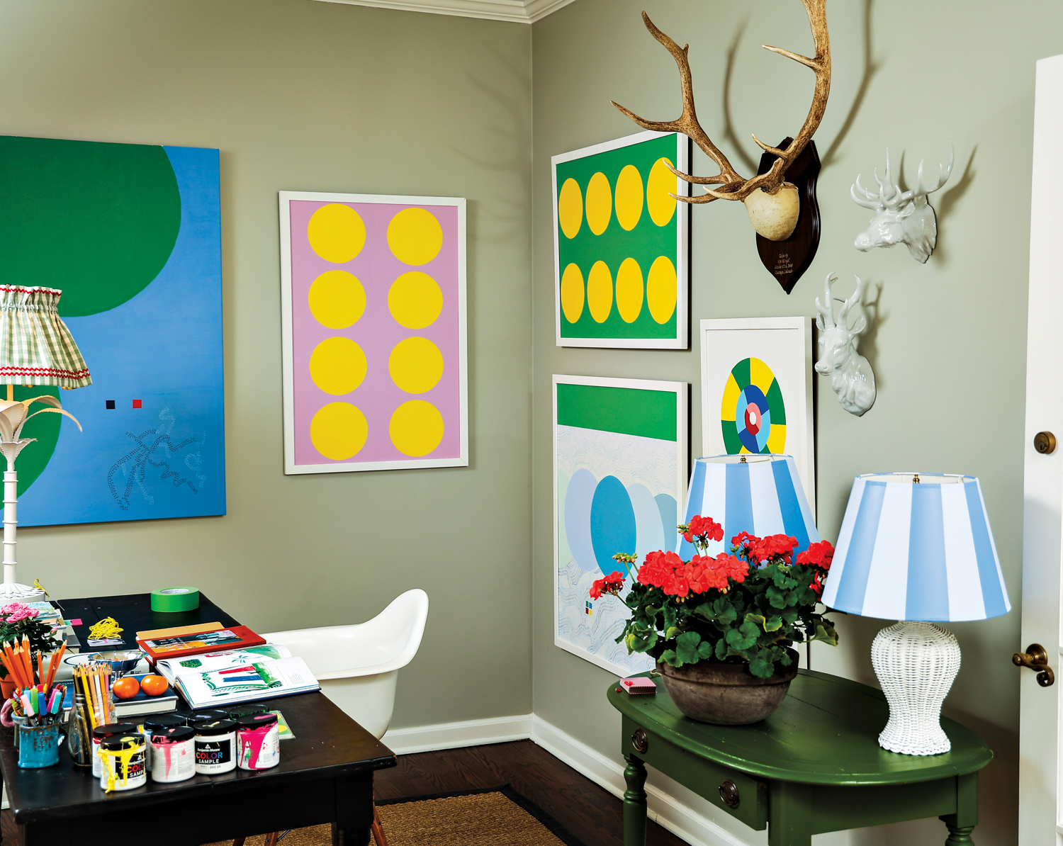 Katie Powell Brickman's art studio featuring her works against sage green walls