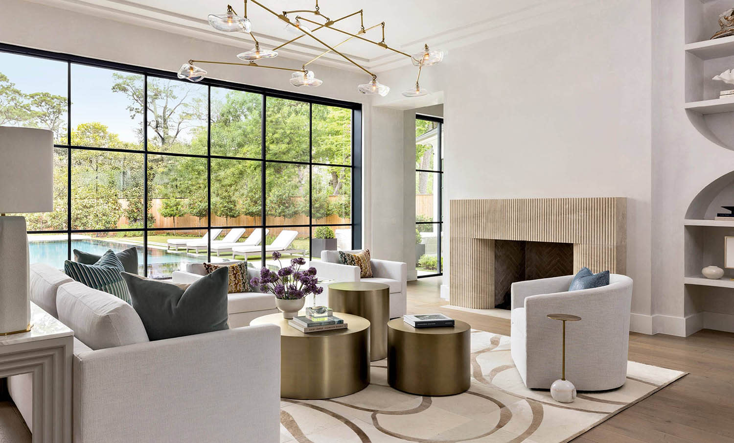A living room space decorated with couches and armchairs arranged around three round tables.