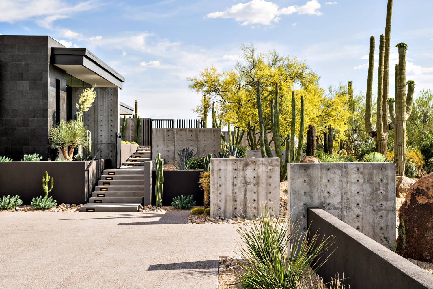 modern home with gray exterior surrounded by cacti