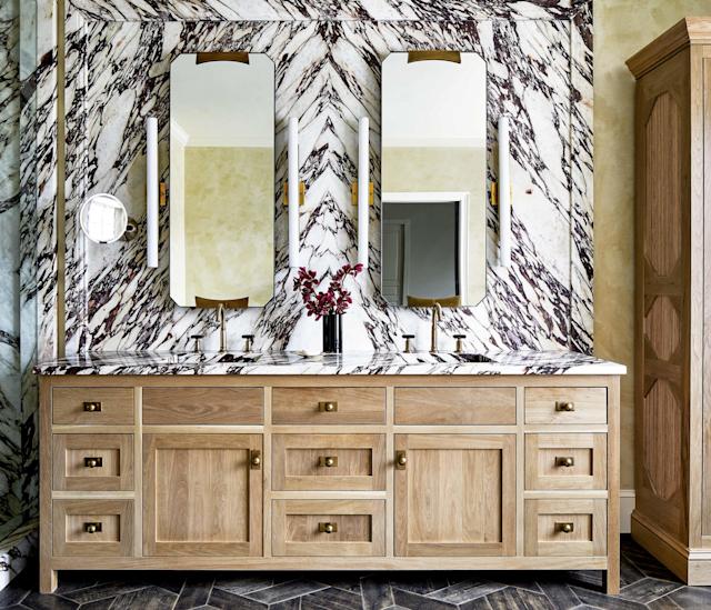 light wood vanity against a luxurious brown and white marble backsplash in a bathroom