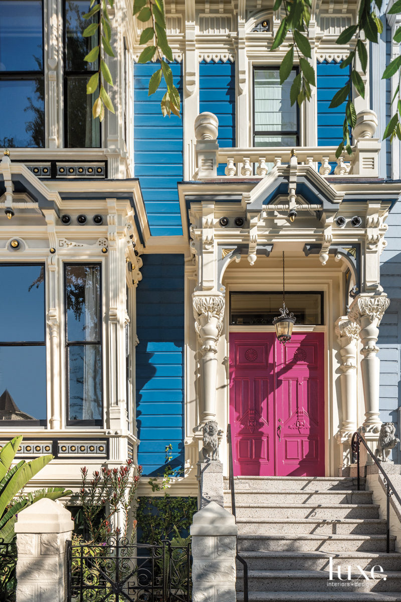 front exterior of blue house with pink door