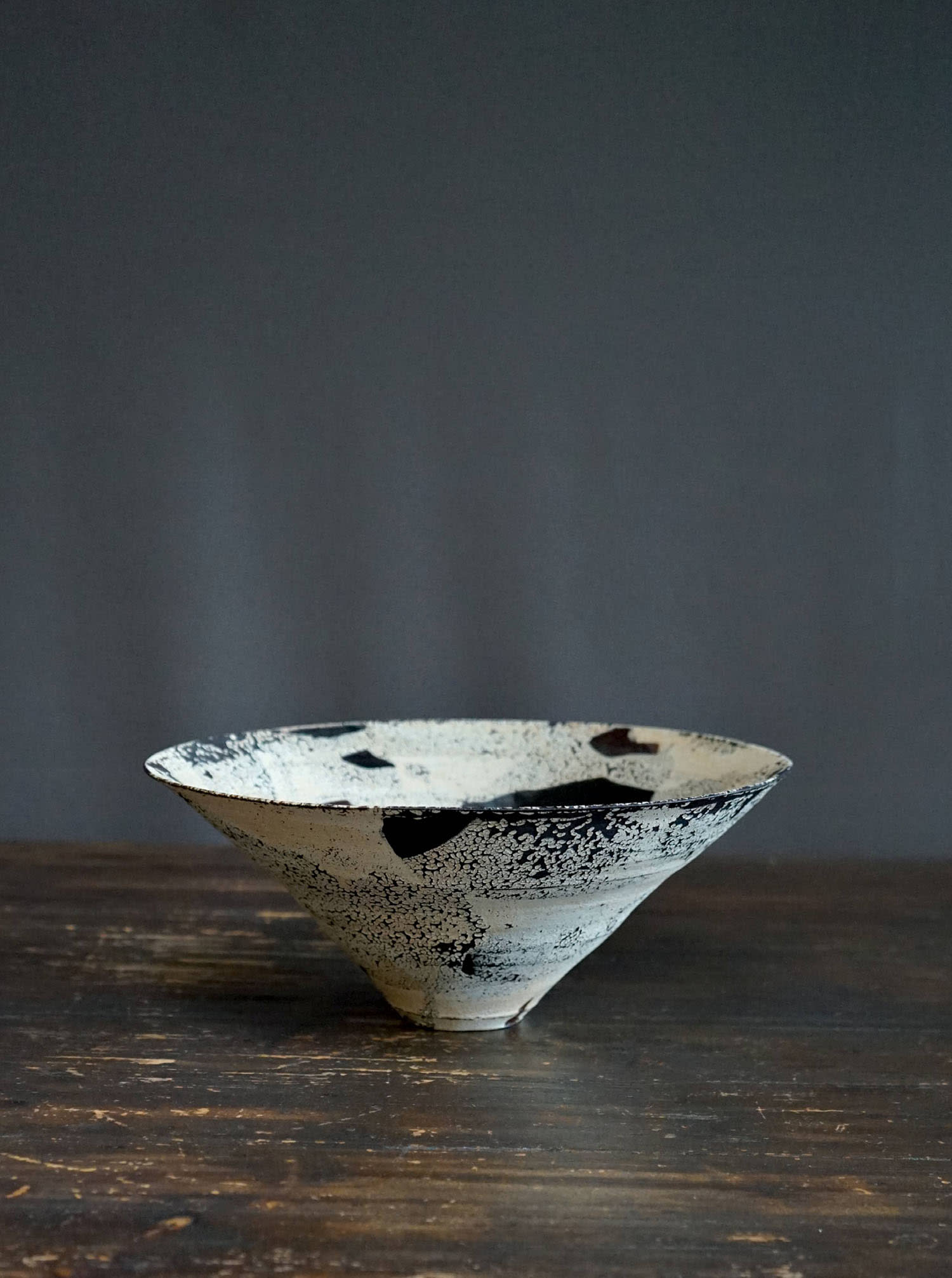 A white pottery bowl with streaks of blue sits on a table.