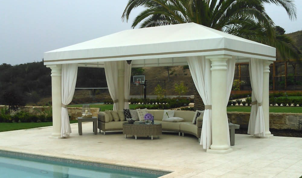 white cabana with drapes and round outdoor sectional