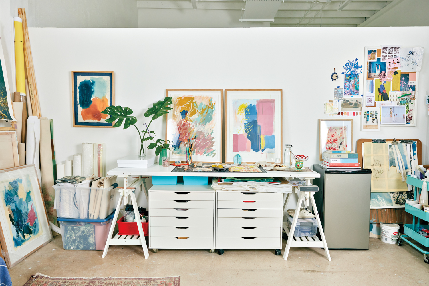 Veronica Pasman's desk in her studio, adorned with colorful artworks