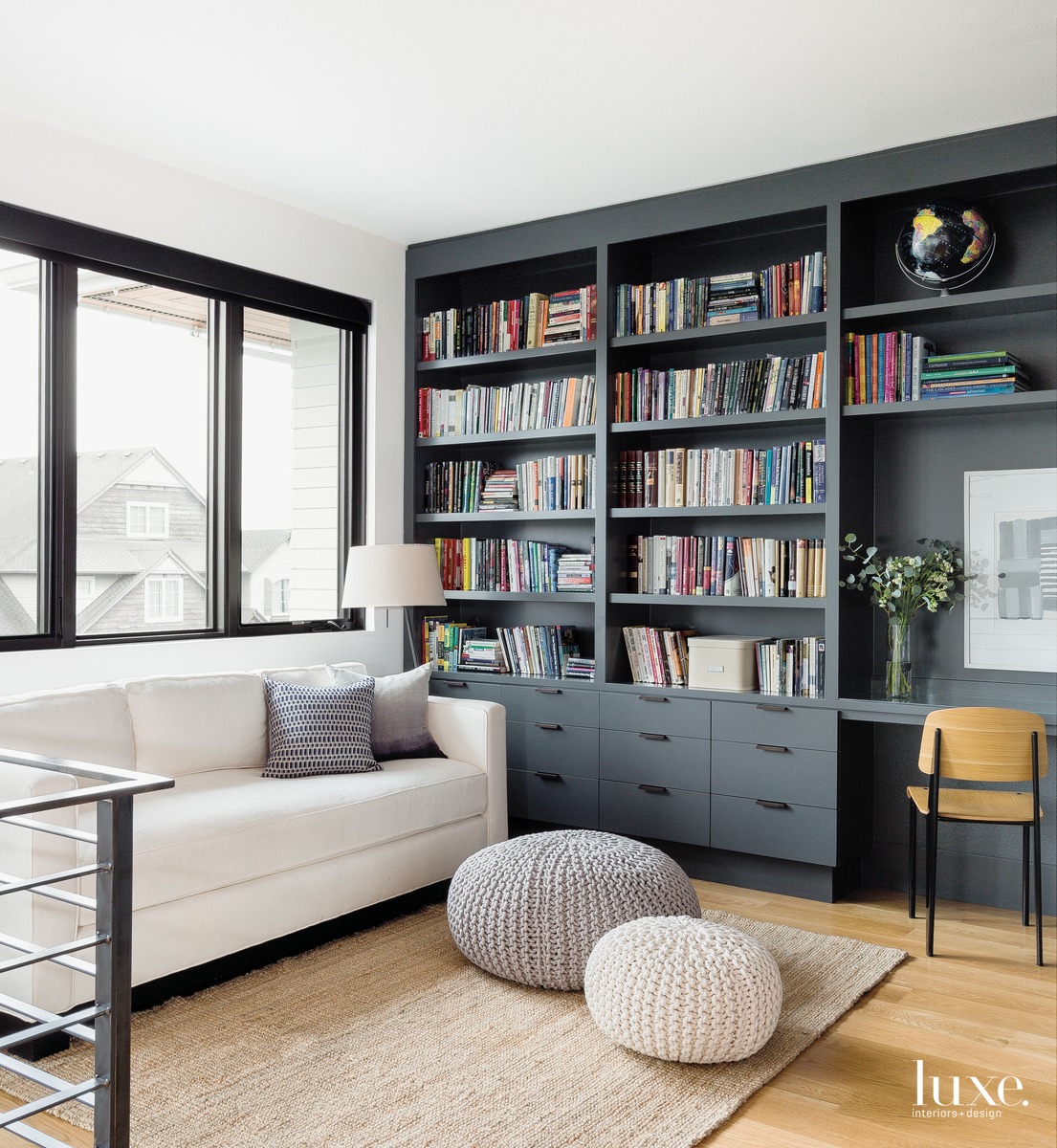 contemporary library loft black shelving white sofa poufs