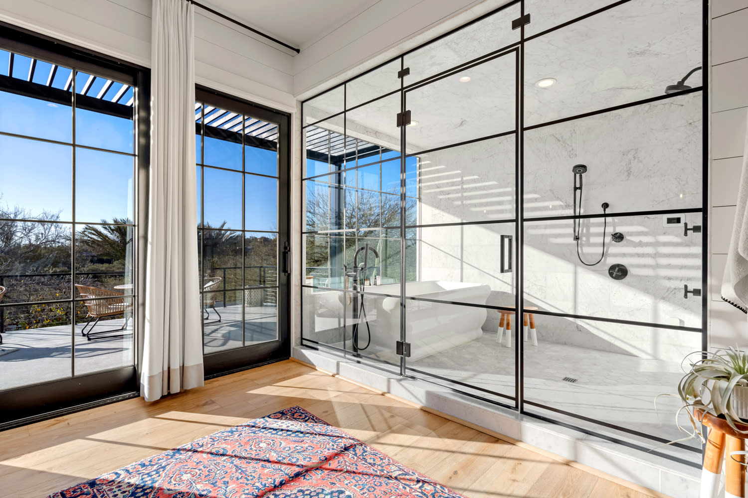 bright primary bath with a large walk-in shower and views of the landscape outside